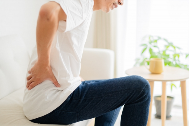 座って腰を押さえる男性