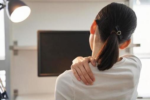 肩を押さえる女性